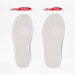 Two white trainer soles side by side. One is standard width and the other is a wider width.