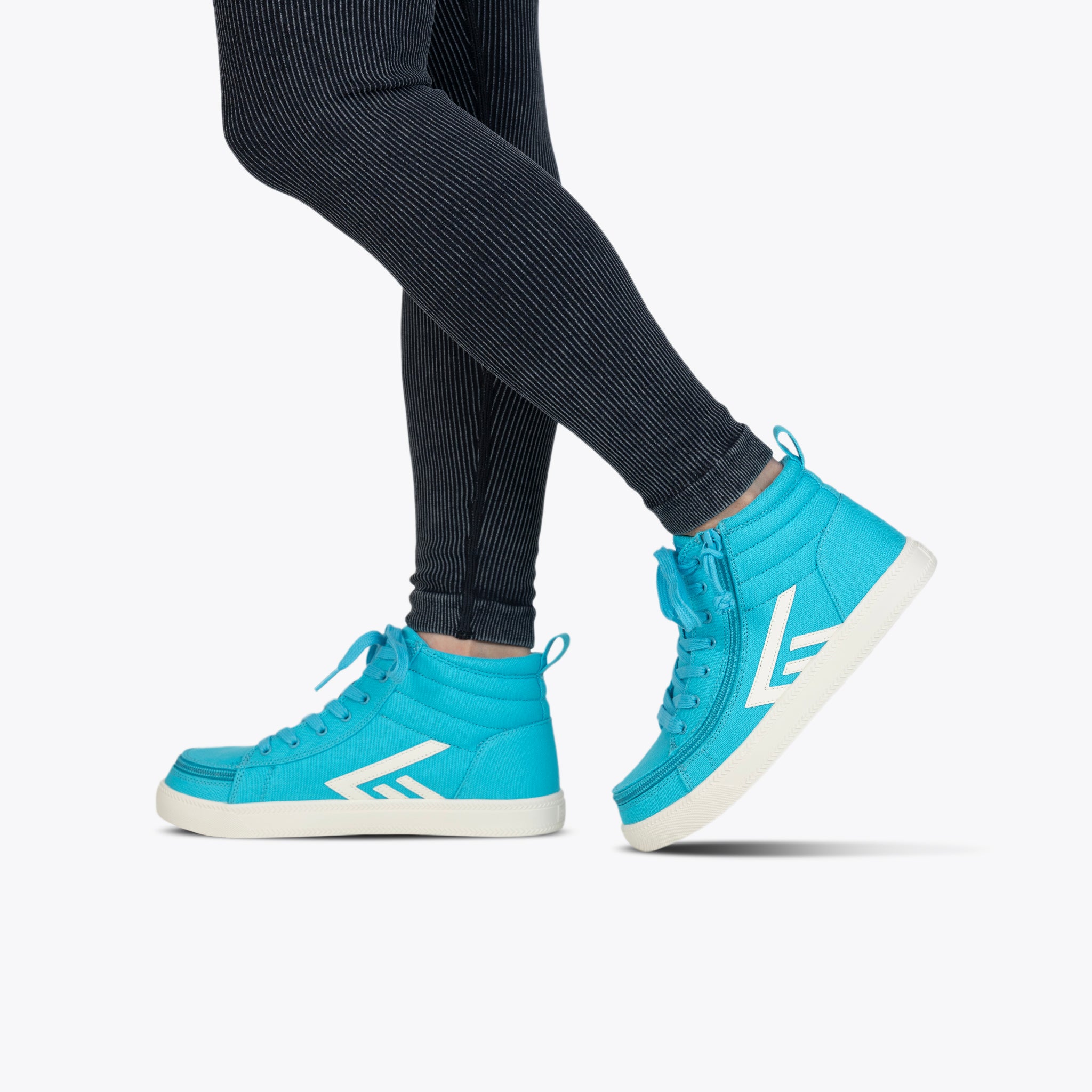 Blue high-top trainers with white accents worn by a person on a white background